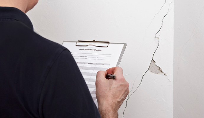Expert inspecting foundation wall